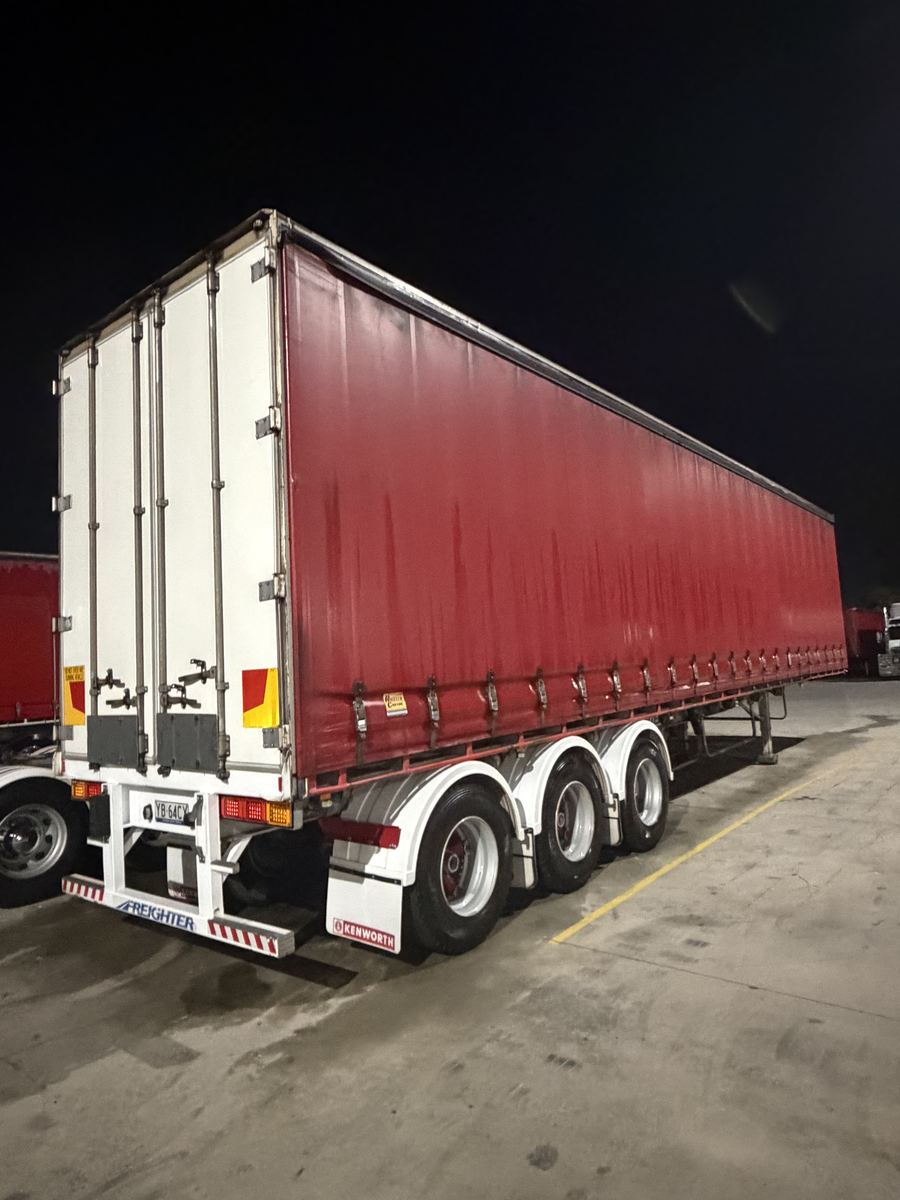 Detailed red curtain-sider trailer at night